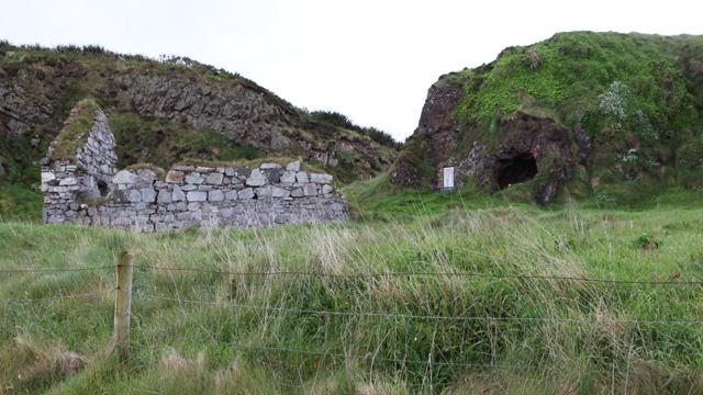 Malin Well Old Church on the left, the glass-covered statue beside it, and the Wee House cave on the right.
